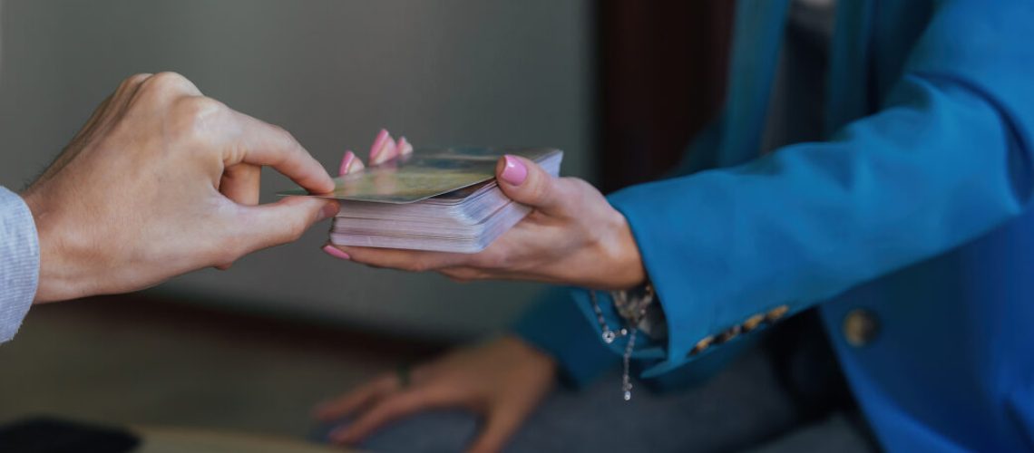 A young beautiful woman psychologist leads a client reception, using metaphorical tarot cards. Universe tips, signs and answers to questions.